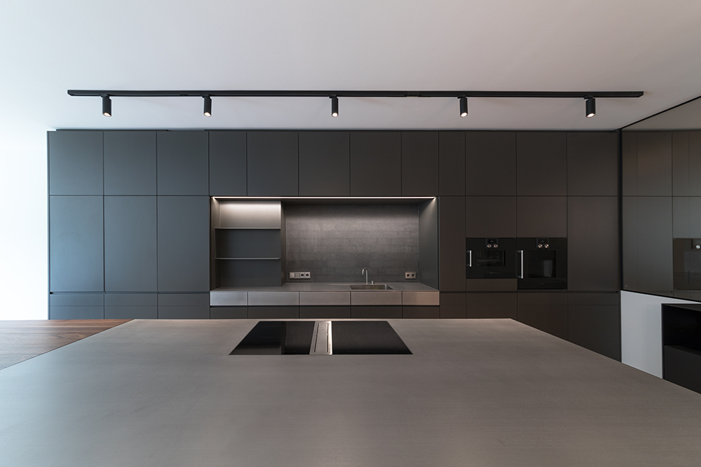 Moderne Küche mit dunklen Fronten, Arbeitsnische und integrierten Geräten im Projekt Townhouse 1180