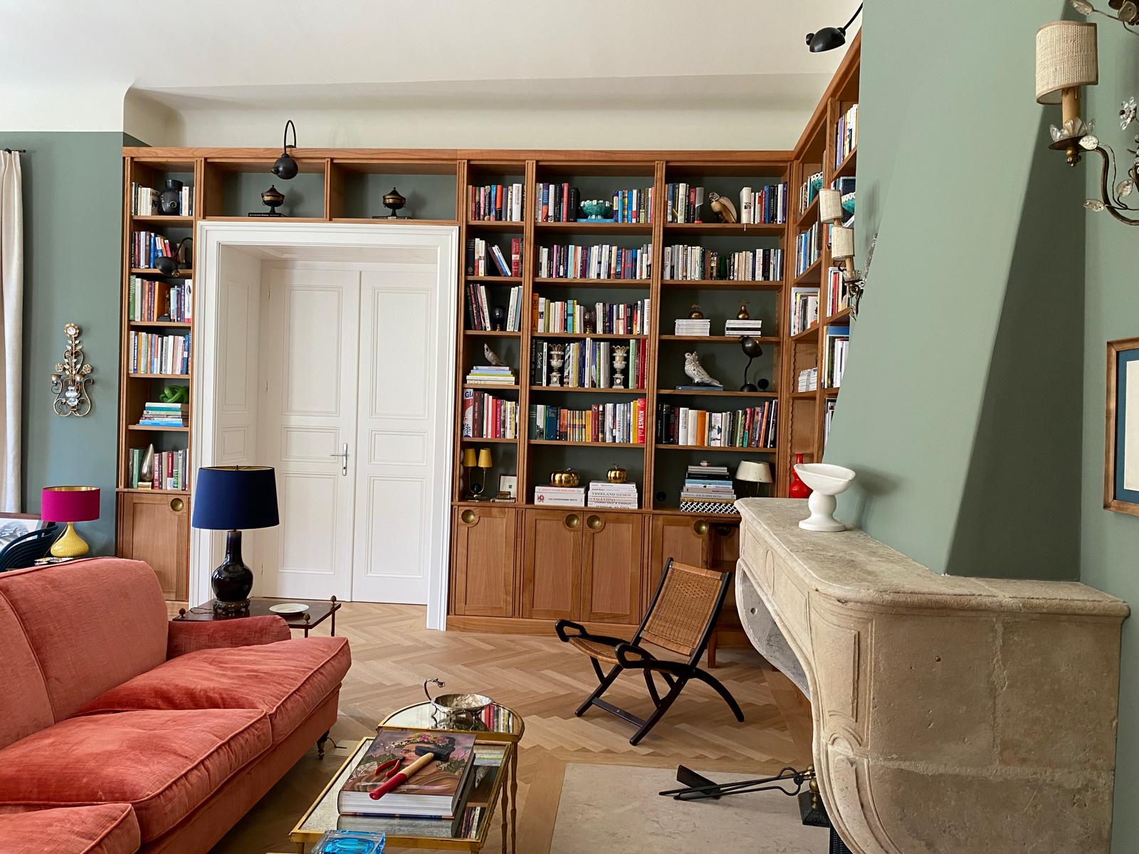 Wohnzimmer mit Bücherwand, Kamin und maßgefertigten Regalen im Projekt Villa in Wien