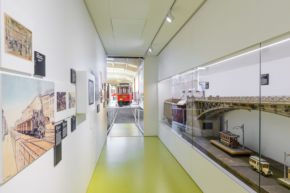 Gangbereich mit Ausstellungswänden, Vitrinen und historischem Straßenbahnmodell